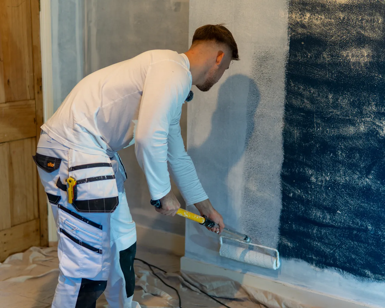 Painter Painting Living Room With Paint Roller