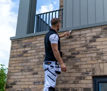 Painter Outside Up Ladder With Paintbrush