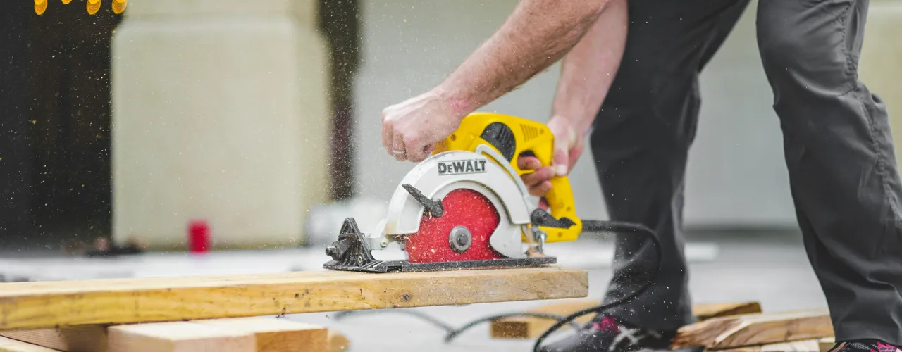 Floorer Cutting Wood With Saw