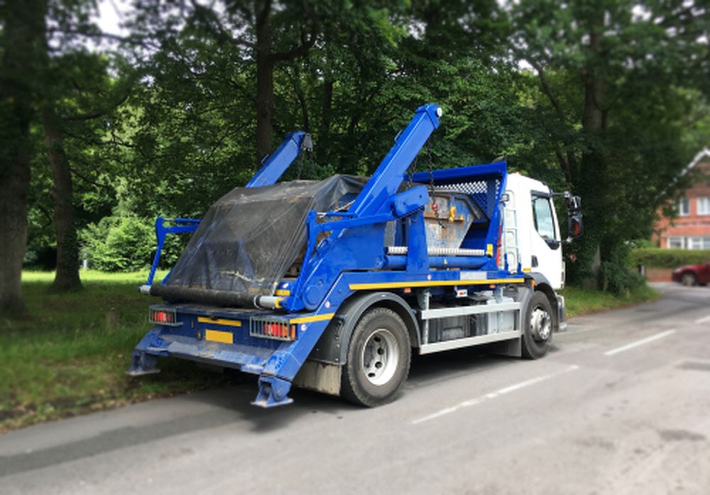 Blue Skip Lorry Driving Away