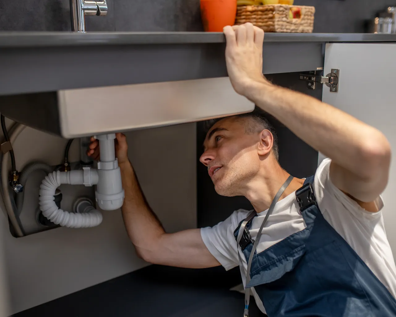 Plumber Examining Bottom Kitchen Sink